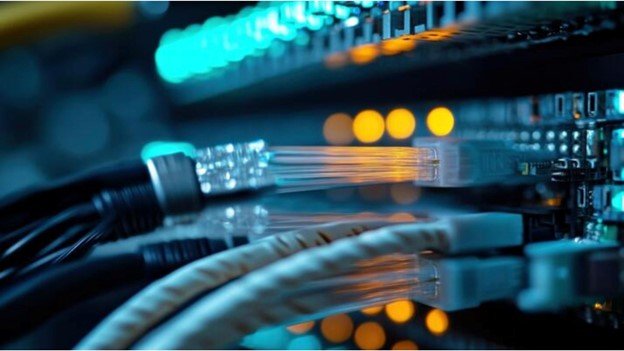 Close-up of Ethernet cables connected to a network switch, with glowing indicator lights in a data center.